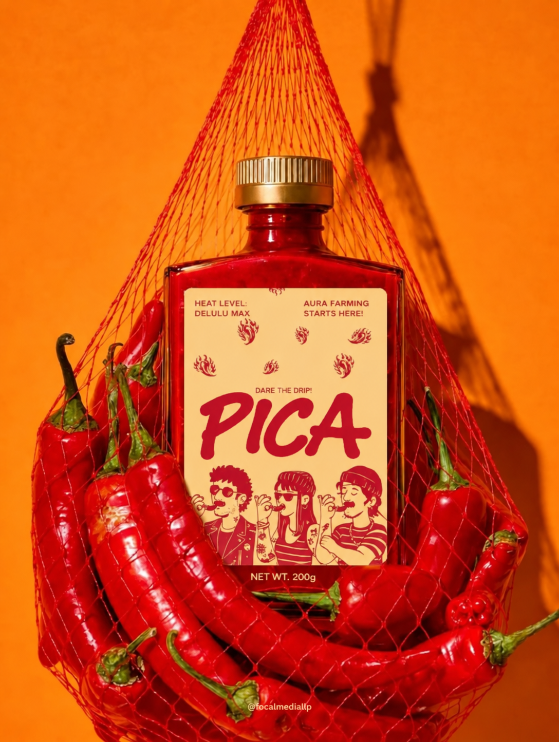 Pica hot sauce bottle in a net bag of red chili peppers on orange