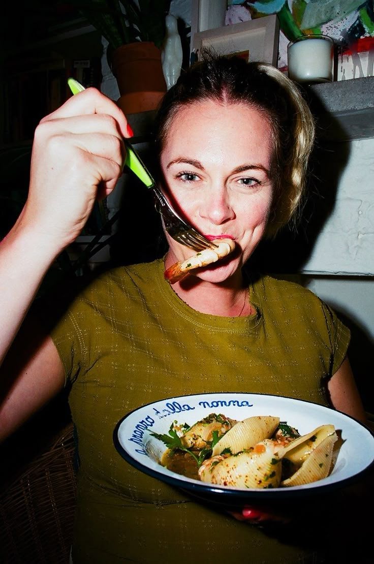 Claudia eating pasta with a green fork